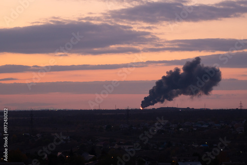 Industrial Smoke Rising Over City at Sunset
