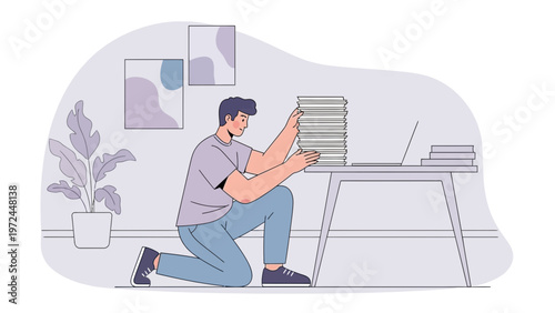 Man kneeling by desk, stacking papers, laptop, office plant, modern interior