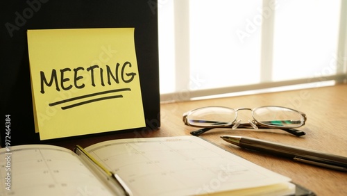 Meeting Reminder Note with Calendar and Office Desk Workspace Planning Concept