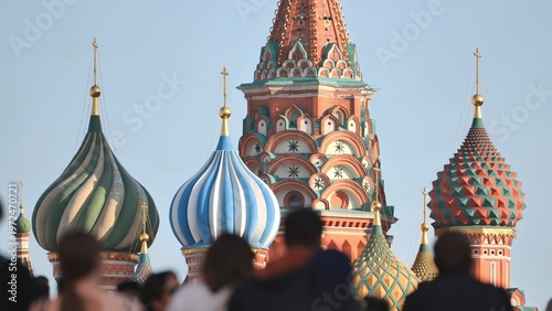 Photos Colorful onion domes of a historic cathedral with a blurred crowd in the foregro