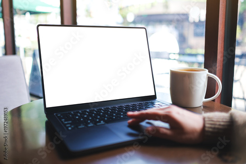 Fotografie Mockup image of a woman working on laptop computer with blank white desktop scre