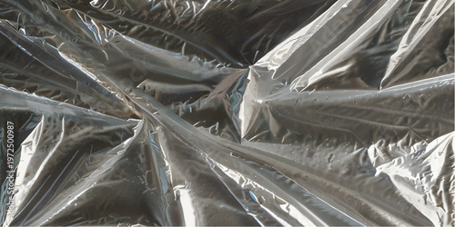 Close up view of crumpled transparent plastic with sharp folds and reflective highlights creating abstract patterns of light and shadow on a dark background surface texture