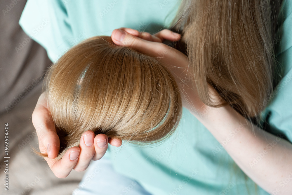 Naklejka premium Woman holding hair gently while checking for split ends at home 