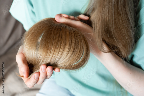 Foto Woman holding hair gently while checking for split ends at home