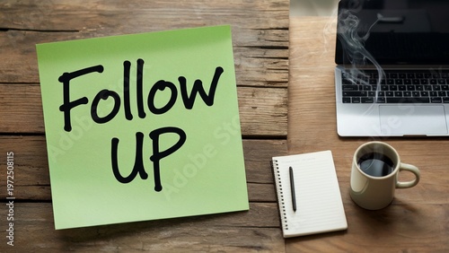 Follow Up Reminder Sticky Note on Wooden Desk with Laptop for Business Productivity