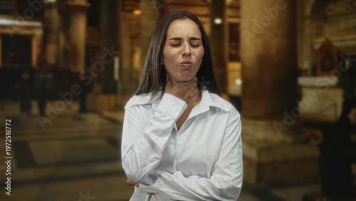 Foto Woman with hand on throat and closed eyes in a church building showing a choking gesture and tense posture; distress