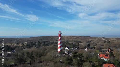 Aerial shot of historic, red and white lighthouse in the dunes of Zeeland, the Netherlands.