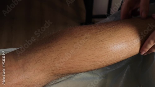 Therapist applying trigger point pressure on male calf muscle for myofascial release