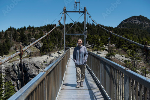 A smiling chinese woman on the mile high swinging bridge on Grandfather Mountain in North carolina