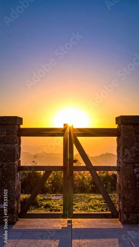 Serene Sunrise Through Open Gate with Mountain View in Background