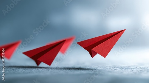 Red paper airplanes flying in a line against a soft background