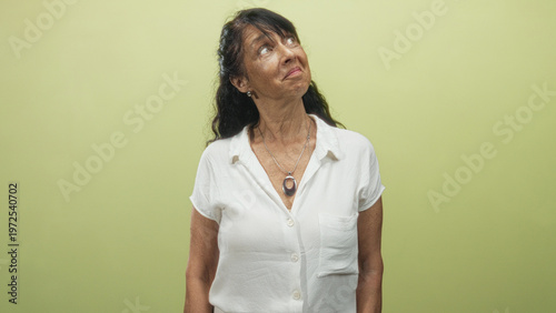 Принти на полотні Woman wearing white blouse and pendant necklace looks up showing bare neck with a gentle smile in studio; serenity