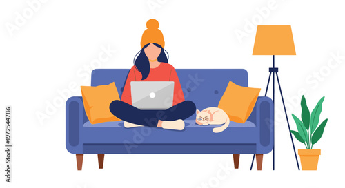 A focused young woman wearing a vibrant orange knit hat works on her silver laptop while sitting comfortably on a plush blue sofa with her white cat.