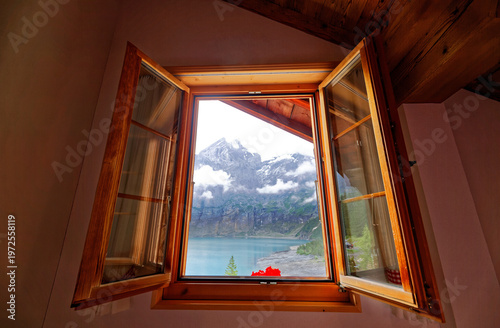 Wallpaper Mural A view of peaceful Oeschinen Lake with majestic rocky mountains in background through the wooden window of a chalet house by the lakeside near Kandersteg, Bernese Highlands, Switzerland, Europe Torontodigital.ca