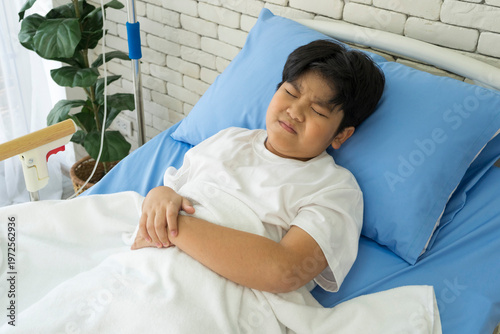 Sick asian boy lying on hospital bed. Healthcare and medical concept.