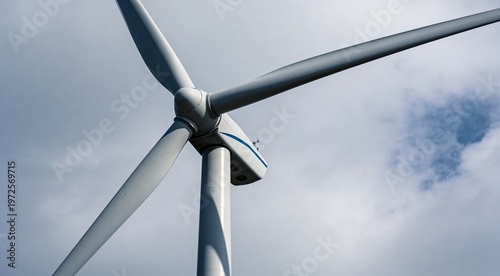 Modern wind turbine against cloudy sky, low angle view. Alternative energy source