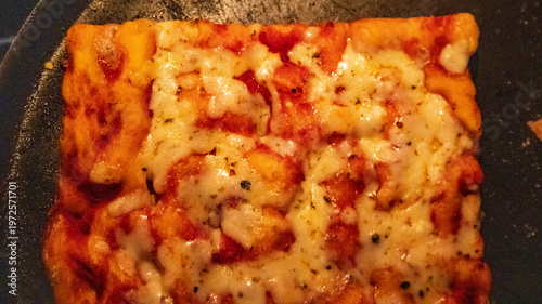 Hot rectangular pizza slice with melted cheese