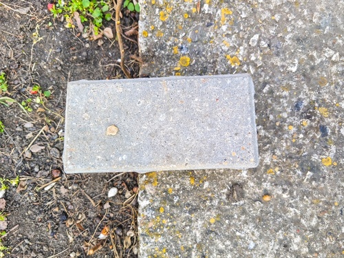 Square concrete slab placed on ground showing construction material detail and rough texture in outdoor environment with realistic composition scene
