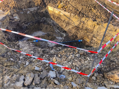 Deep excavation trench with marked boundaries showing construction site digging process and infrastructure development in outdoor environment scene