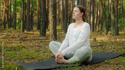 Woman meditates, relaxes and make yoga exercises in the woods alone