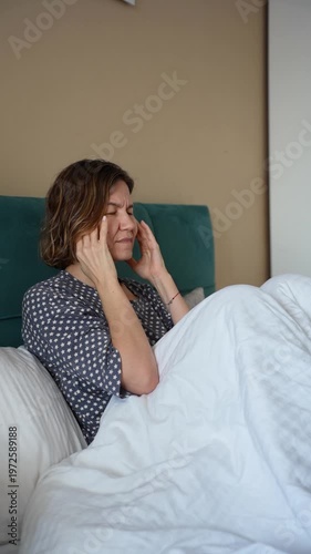 Blonde Mature Woman with Headache Feeling Exhausted and Burned Out in Bedroom