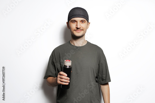 Young man holding thermos in hands isolated on white background.Young man holding thermos in hands isolated on white background.