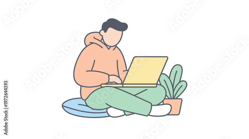 Young man using laptop computer while sitting on floor with plant and pillow.