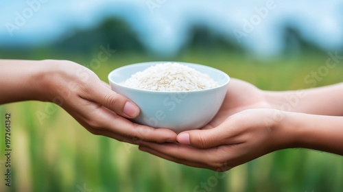 Hands sharing a bowl of rice, symbolizing charity, food donation, poverty relief, and humanitarian aid