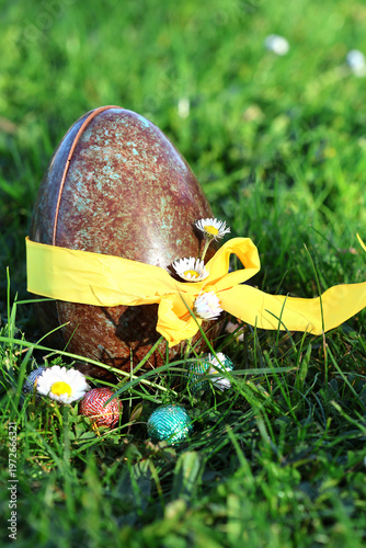 PARIS, FRANCE - APRIL 4, 2026: A large chocolate Easter egg hidden in the green grass. The Easter egg hunt tradition
