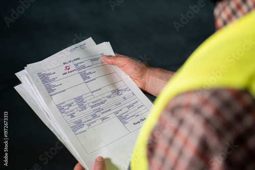 Cuadro en lienzo Warehouse worker reviewing documents or bill of lading