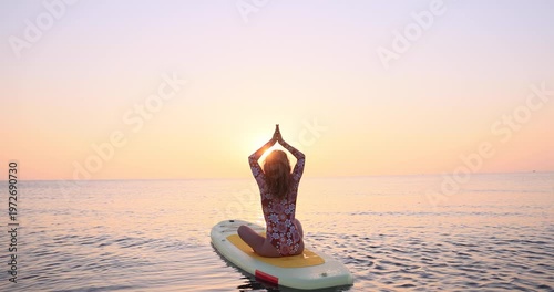 Young woman walking on sup board by the sea during summer vacation. Slow motion