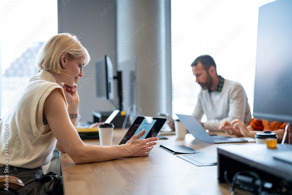 Fototapeta premium Businesswoman watching analytics on digital tablet in office