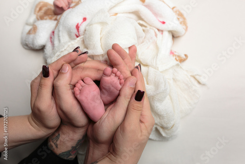 Parents holding newborn baby's feet in hands