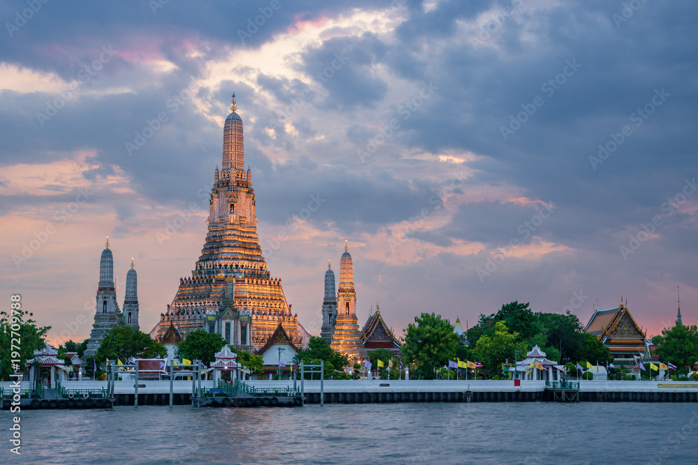 Fototapeta premium Majestic sunset over Wat Arun (Temple of Dawn) along the Chao Phraya River, Bangkok, Thailand