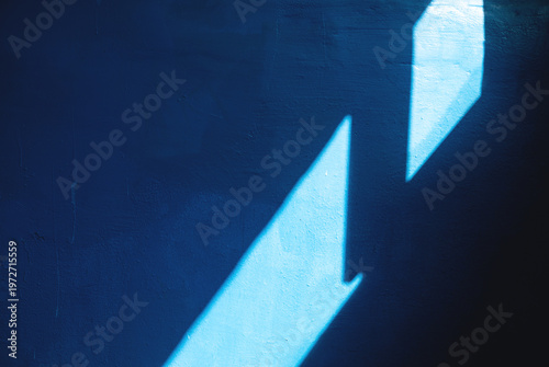 Sun rays on blue painted wall, light and shadow abstract background