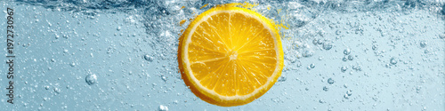 Fresh lemon slice submerged in sparkling water with bubbles rising, showcasing vibrant yellow color and refreshing citrus texture in minimal style macro shot