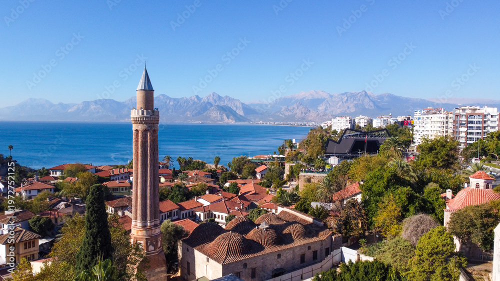 Fototapeta premium Aerial High Angle View of Historic Yivli Minaret Mosque and Kaleici Old Town with Taurus Mountains in Antalya Turkey