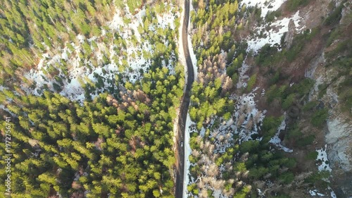 Aerial top down view of winding road in snowy Jura mountains