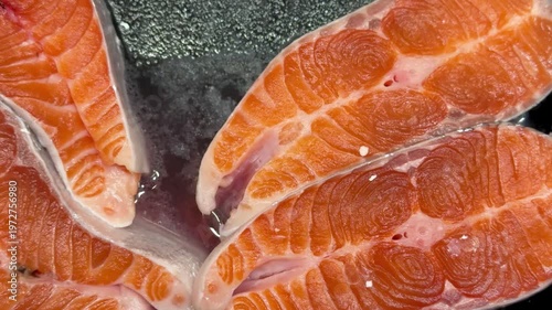 Chilled chum salmon steaks from frozen raw materials on a substrate for sale in a supermarket. Close-up.