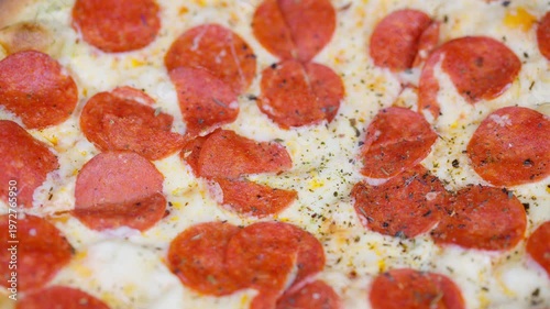 Delicious pizza closeup. Melted cheese on spicy pizza. Golden crust with delicious toppings and melted cheese. Closeup of flavorful pepperoni pizza with crust and cheese details