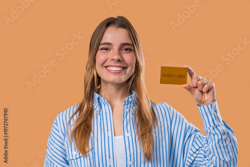 Successful Woman In Blue Outfit Showing Unlimited Gold Credit Card On Beige