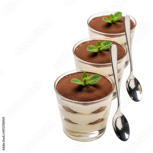 Three tiramisu desserts with mint and spoons