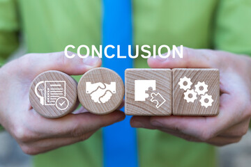 Concept of conclusion. Business person holding wooden blocks with icons sees the text CONCLUSION.