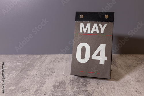 4 Mai on wooden grey cubes. Calendar cube date 04 May.
