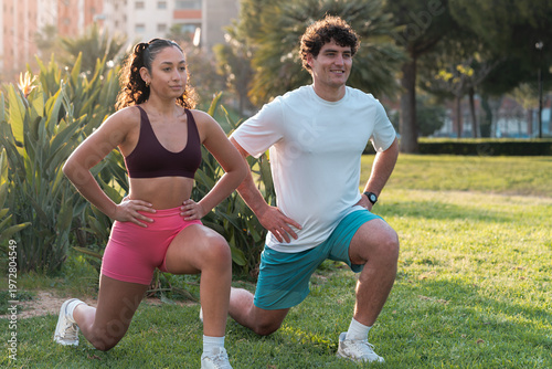 Cuadro en lienzo Young couple performing lunges outdoor in park