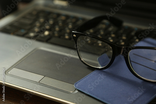 Business concept closeup portrait in different light with same camera manual and composition. Glasses, paper notebook, mobile phone on laptop keyboard. Research idea, study, work. No people, nobody. 