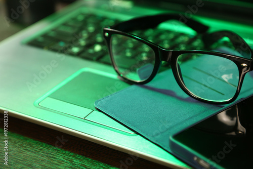 Business concept closeup portrait in different light with same camera manual and composition. Glasses, paper notebook, mobile phone placed on laptop keyboard. Research, study, work. No people, nobody.