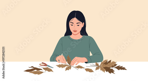 Woman hands arranging dried autumn leaves for crafting, surrounded by fall foliage on a table with scissors