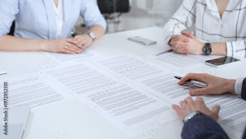 Принти на полотні Business partners discussing contract terms, reviewing legal documents during an