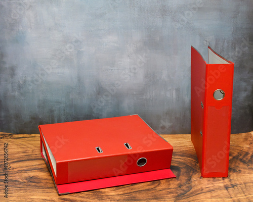 Obraz na plátne red lever arch folders on a wooden table surface